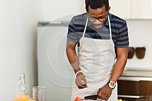 African man preparing healthy food at home in kitchen