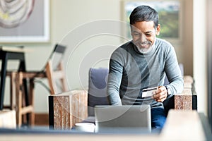 Attractive bearded hipster asian father or Hispanic old man using Laptop and credit card payment shopping online with customer photo