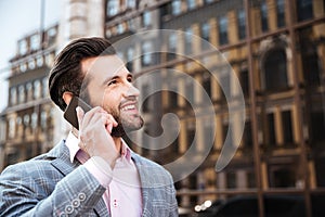 Attractive bearded man in jacket talking on mobile phone