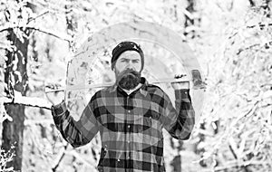 Attractive bearded man outdoors in winter. A man in a winter forest. A woodman working in the forest. Man inspecting