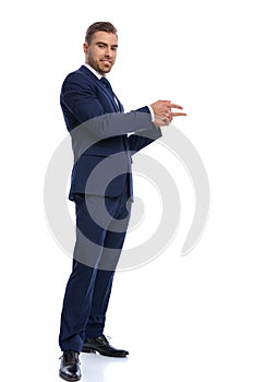 Attractive bearded man smiling and pointing fingers to side