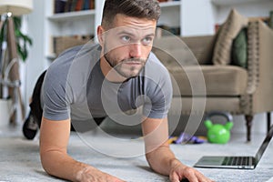 Attractive beared man doing plank exercise at home. Fitness is the key to health