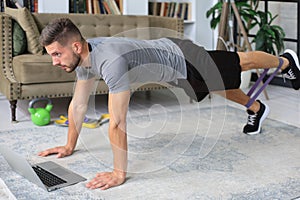 Attractive beared man doing plank exercise at home. Fitness is the key to health