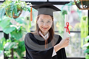 Attractive Beautiful Asian Graduated woman in cap and gown smile with certificated feeling so proud