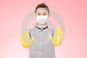 Attractive Beautiful Asian woman maid wearing face mask and gloves smile and open palm stop sign feeling so happiness and confiden