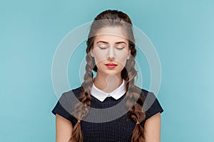 Attractive beautiful calm woman with braids standing with closed eyes, having problems with eyesight