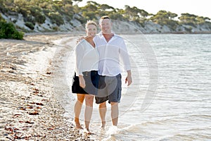 Attractive beautiful couple in love walking on the beach in romantic summer holidays