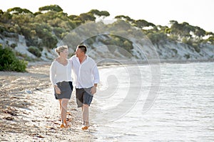 Attractive beautiful couple in love walking on the beach in romantic summer holidays