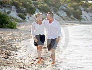 Attractive beautiful couple in love walking on the beach in romantic summer holidays