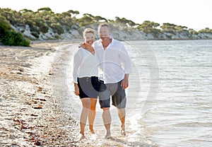 Attractive beautiful couple in love walking on the beach in romantic summer holidays