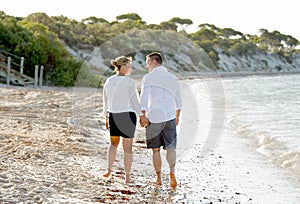 Attractive beautiful couple in love walking on the beach in romantic summer holidays