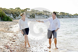 Attractive beautiful couple in love walking on the beach in romantic summer holidays