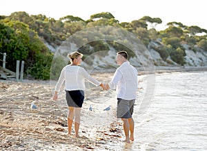 Attractive beautiful couple in love walking on the beach in romantic summer holidays