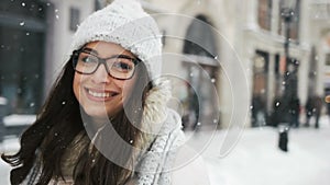 Attractive beautiful lady posing and flirting on camera over snowy city background