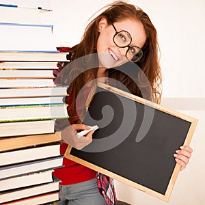 Attractive beautiful woman geek with a blackboard and pile of bo
