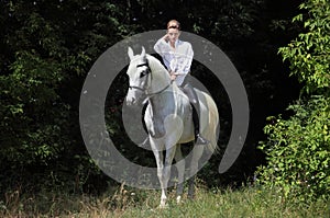 Attractive beauty equestrian girl bareback white horse dark woods portrait