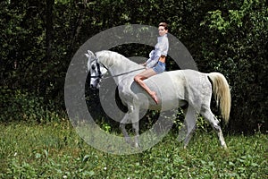 Attractive beauty equestrian girl bareback white horse dark woods portrait