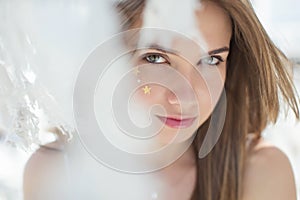 Attractive beauty woman face with star make up freckles. Portrait of a girl.