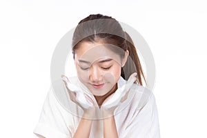 Attractive beauty young asian woman washing up her face with foam cleanser in the morning. Happy pretty girl cleaning her face