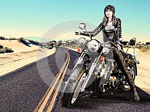 Attractive Biker Girl Sits On Her Motorcycle In The Desert