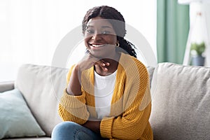 Attractive black lady posing on couch at home