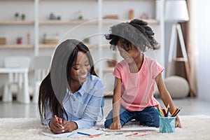 Attractive black mother spending time with her little daughter