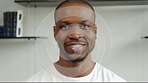 An attractive black student with a small beard and mustache, looking into the camera with a confident and thoughtful