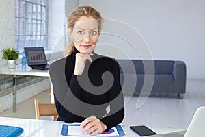 Attractive blond businesswoman sitting in the office