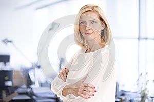 Attractive blond haired businesswoman portrait while standing in the office