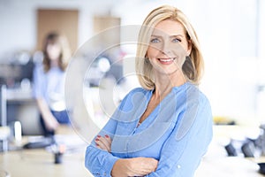 Attractive blond haired businesswoman portrait while standing in the office