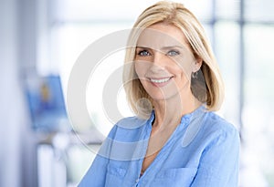 Attractive blond haired businesswoman portrait while standing in the office