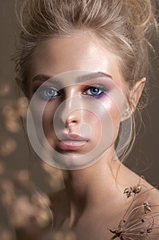 Attractive blond model with a curl hairstyle, colorful smoky eyes and perfect glossy skin. Close up portrait.