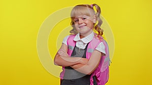 Attractive blond teenage student girl kid in school uniform wears pink backpack holding crossed arms