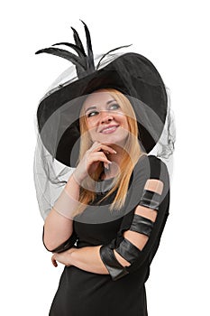 Attractive blond woman with green eyes looks up in black witch hat. Young witch, vertical frame. Halloween party, white background