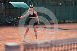 Attractive Blond Woman Serving The Ball With a Racket. Playing Tennis Outdoors.