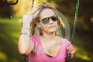 Attractive Blond Woman on Swingset photo