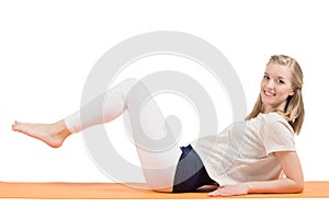Attractive blond woman training stomach, buttocks, hips and legs on a mat