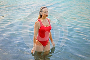 Attractive blond woman walking through the water
