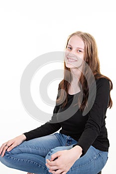 Attractive blond young woman portrait of beautiful girl sitting cross-legged on a white background