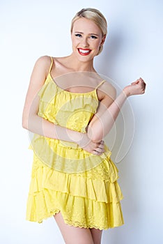 Attractive blond young woman posing in yellow dress