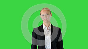 Attractive blonde business woman walking on a Green Screen, Chroma Key.