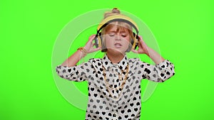 Attractive blonde child kid listening music via headphones dancing disco fooling having fun party