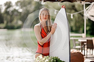 Attractive blonde girl holding a white wakeboard