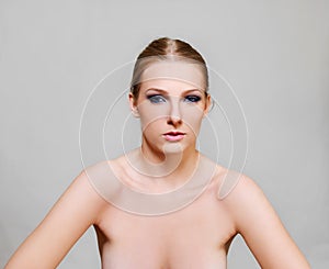 Attractive blonde naked woman with dark eye make up