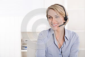 Attractive blonde senior businesswoman with headphone.