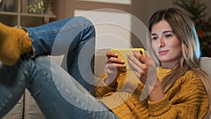 Attractive blonde student girl texting on her phone. Woman using smartphone to communicate with friends in social