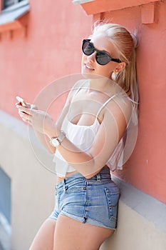 Attractive blonde teenage girl using smartphone