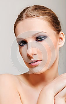 Attractive blonde topless woman with dark eye make up