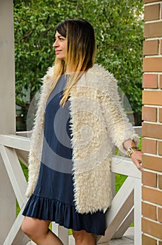 Attractive blonde woman of forty is standing on the porch of a c