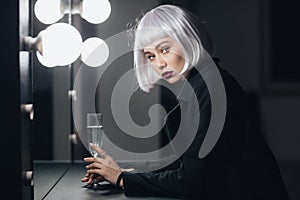 Attractive blonde woman with glass of champaigne in dressing room